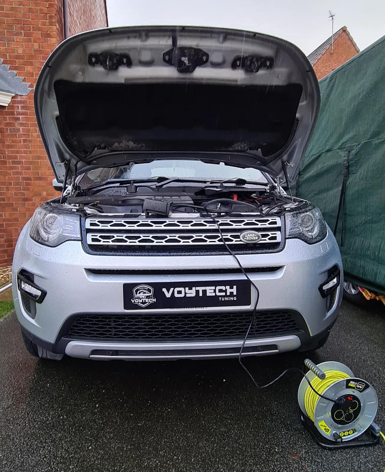 Silver Land Rover Discovery Sport with the bonnet open and a VOYTECH plate