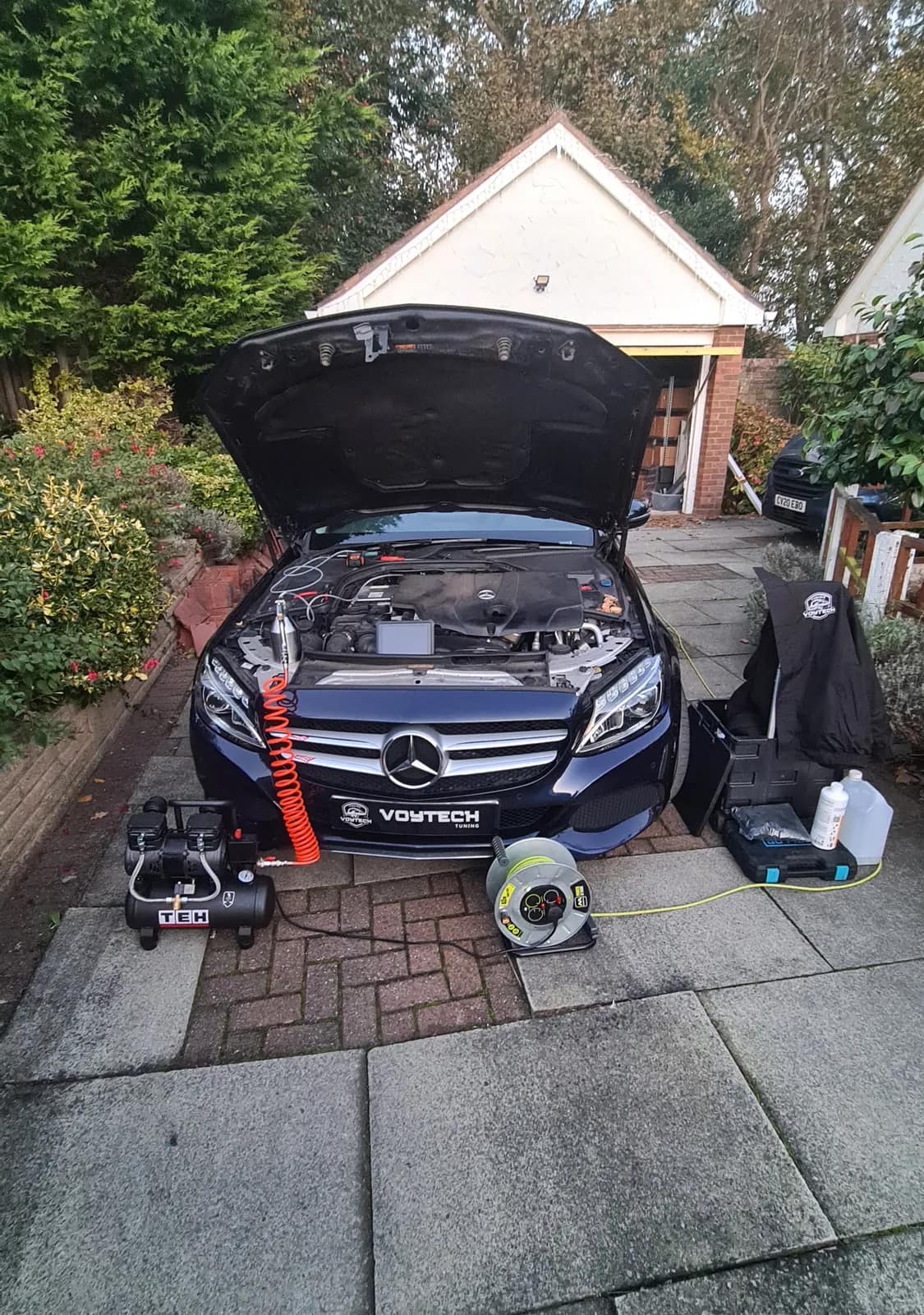Mercedes C-Class with the bonnet open and the DPF cleaning compressor in front