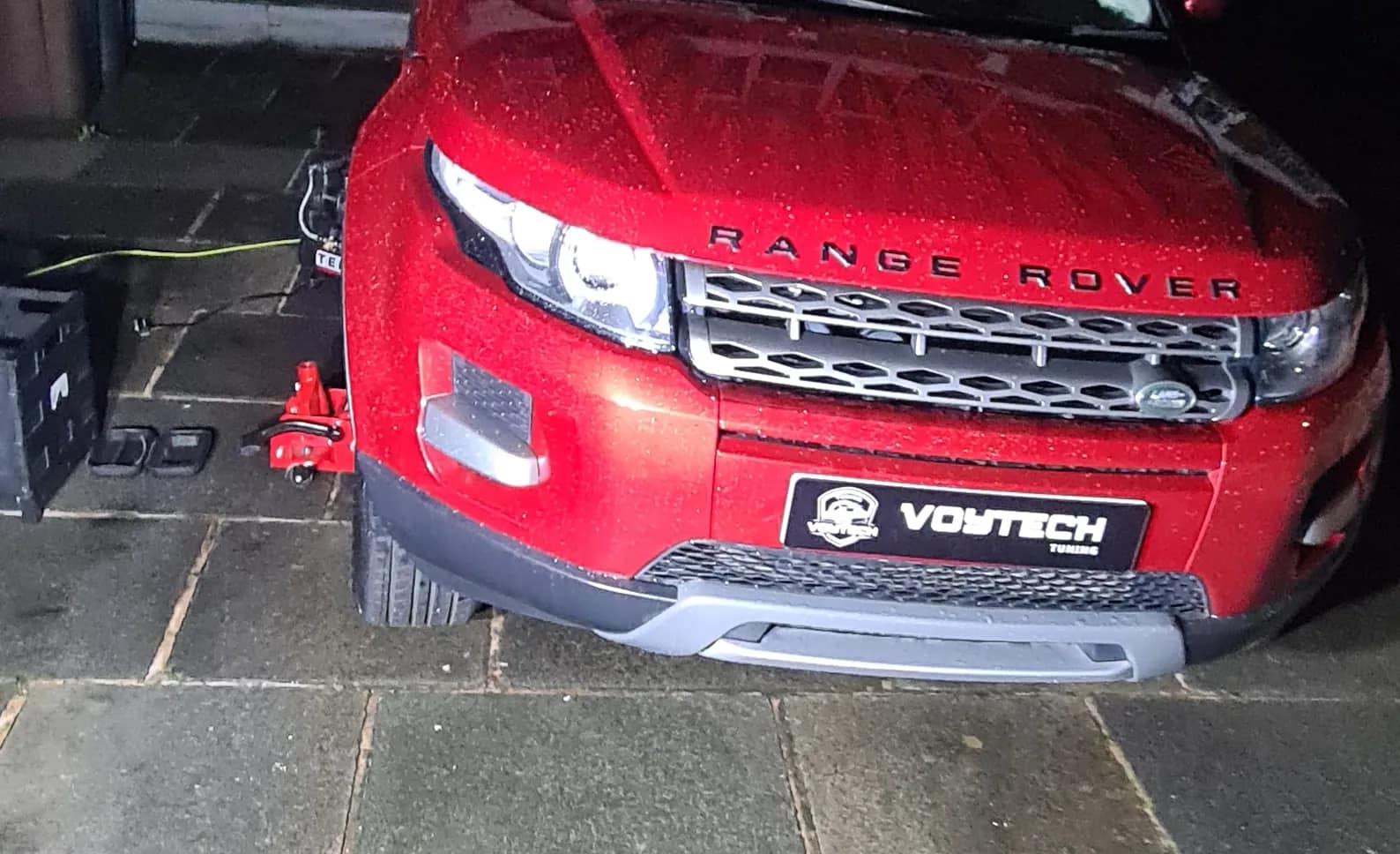 Red Range Rover Evoque with the bonnet open on a job