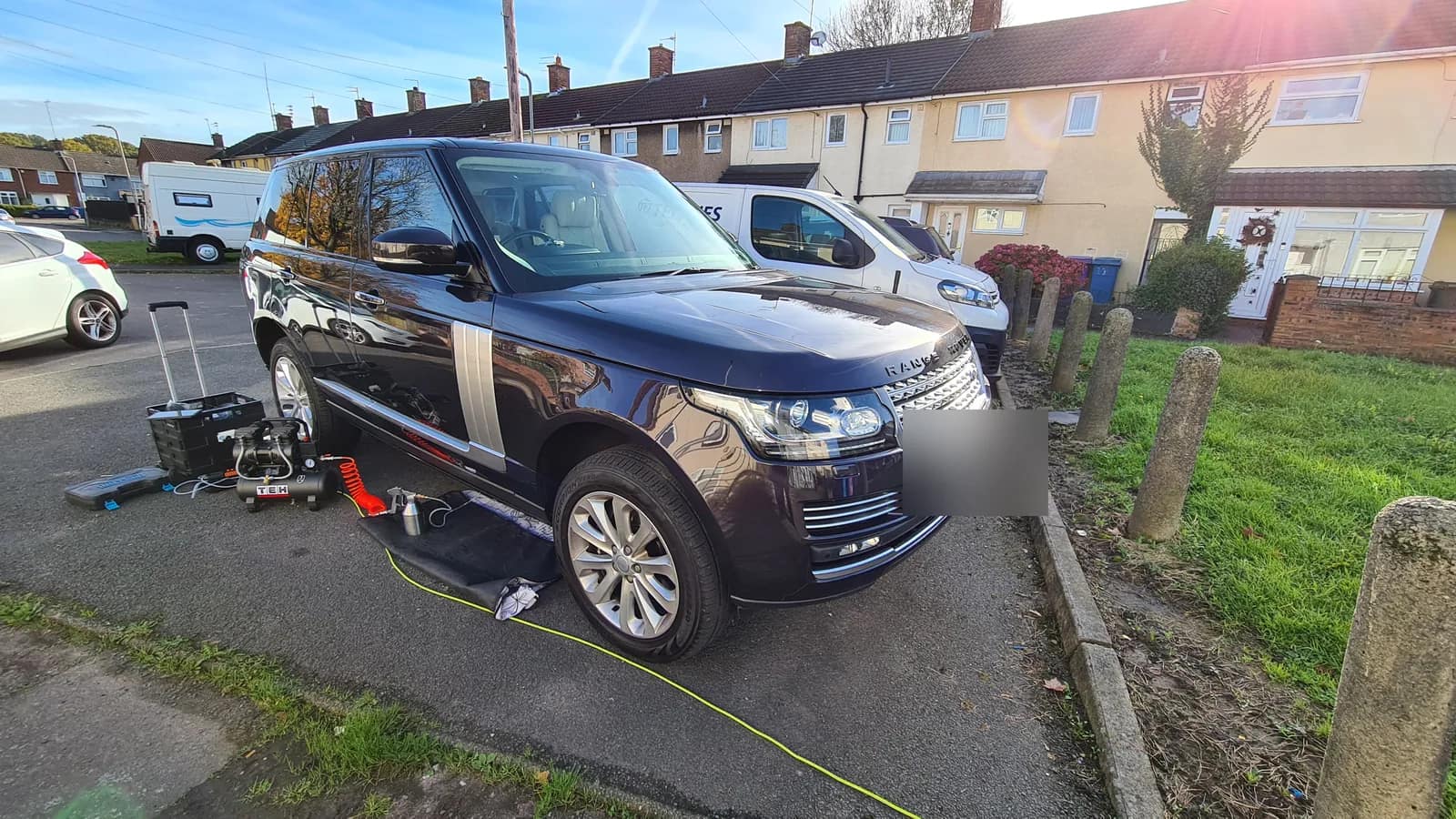 Dark blue Range Rover Vogue on a street with the mobile DPF cleaning kit beside the front wheel