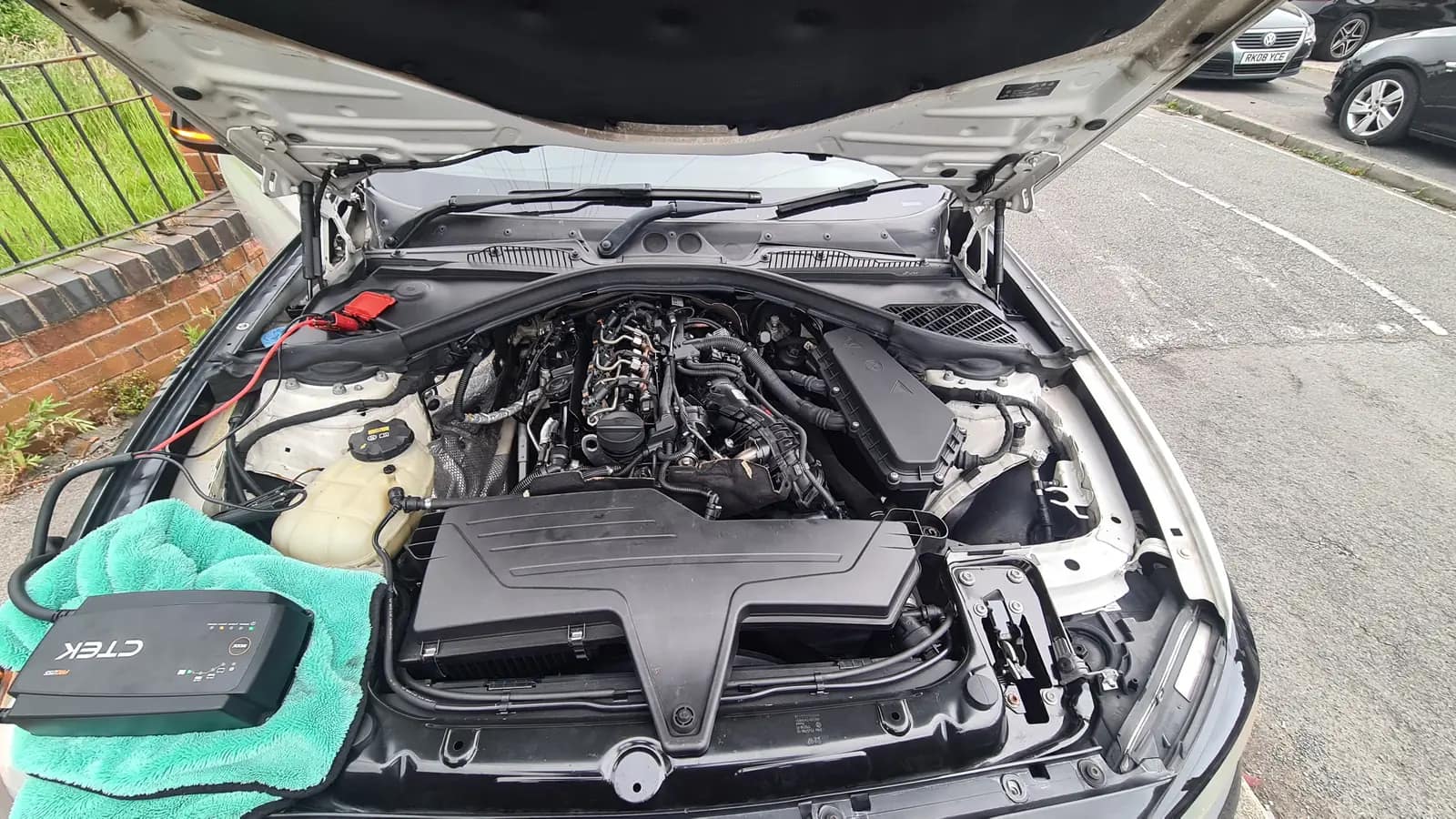 BMW engine bay with a protective wing cover during a remap