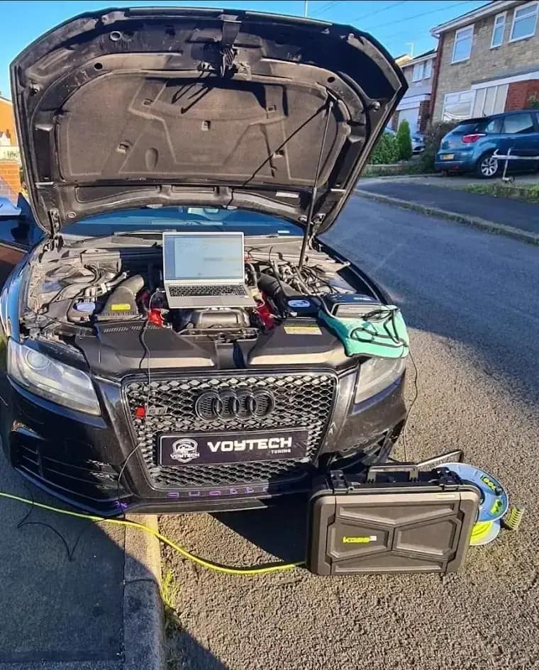 Audi with the bonnet up and a laptop on the engine during a mobile ECU remap on a driveway