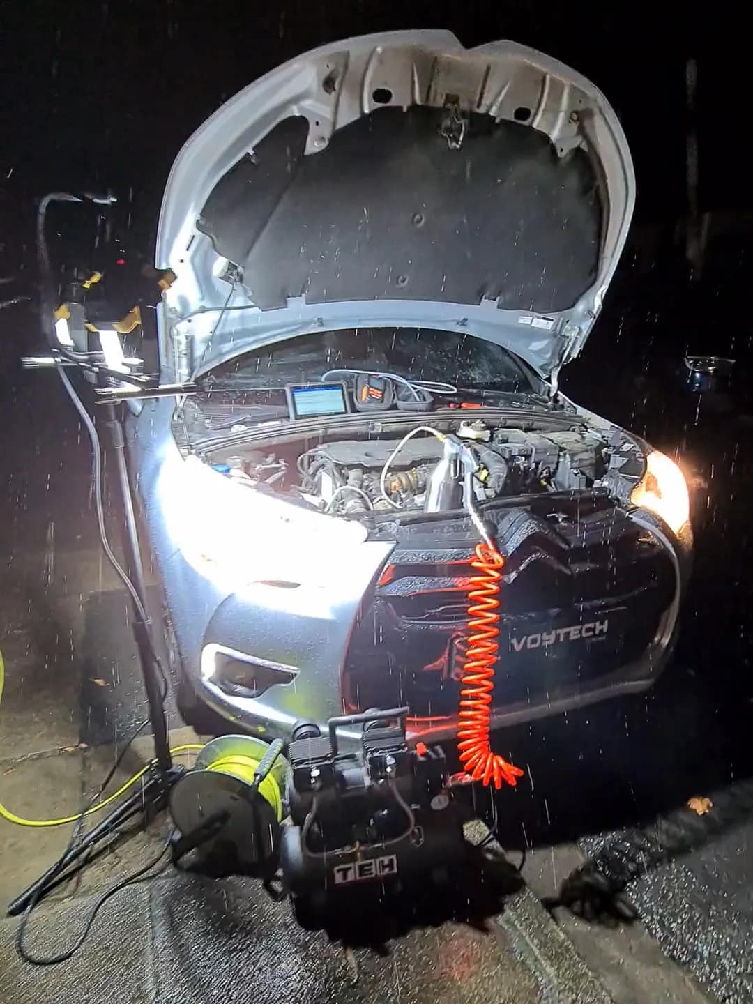 Mobile DPF cleaning kit connected to a Citroen DS4 at night in the rain