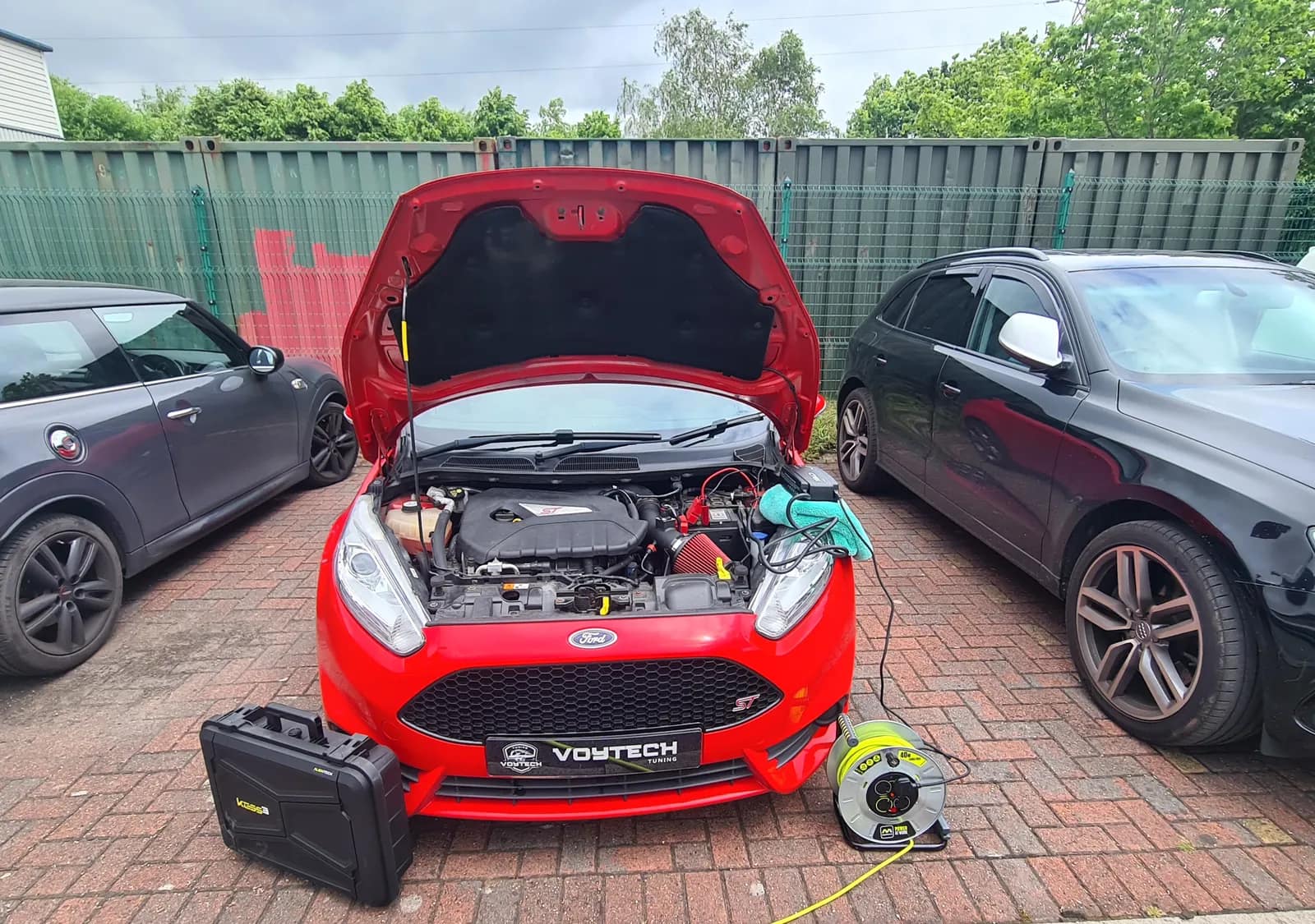 Red Ford Fiesta ST with the bonnet open and a laptop connected, VOYTECH plate on the front