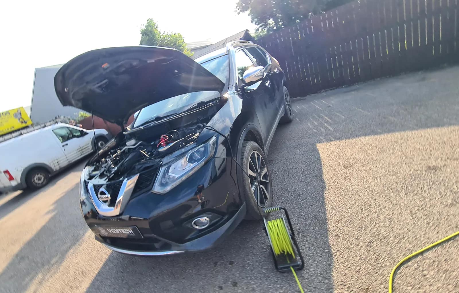 Black Nissan X-Trail with the bonnet open and the Voytech cable reel beside it