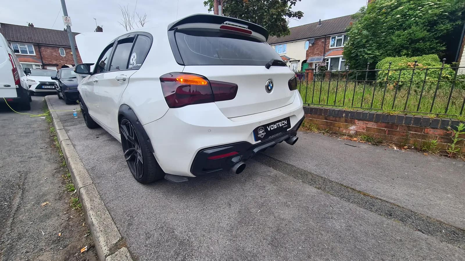 White BMW hatchback with a VOYTECH plate on the rear