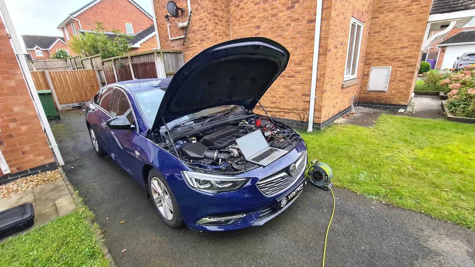 Blue Vauxhall with the bonnet up on a driveway during a remap